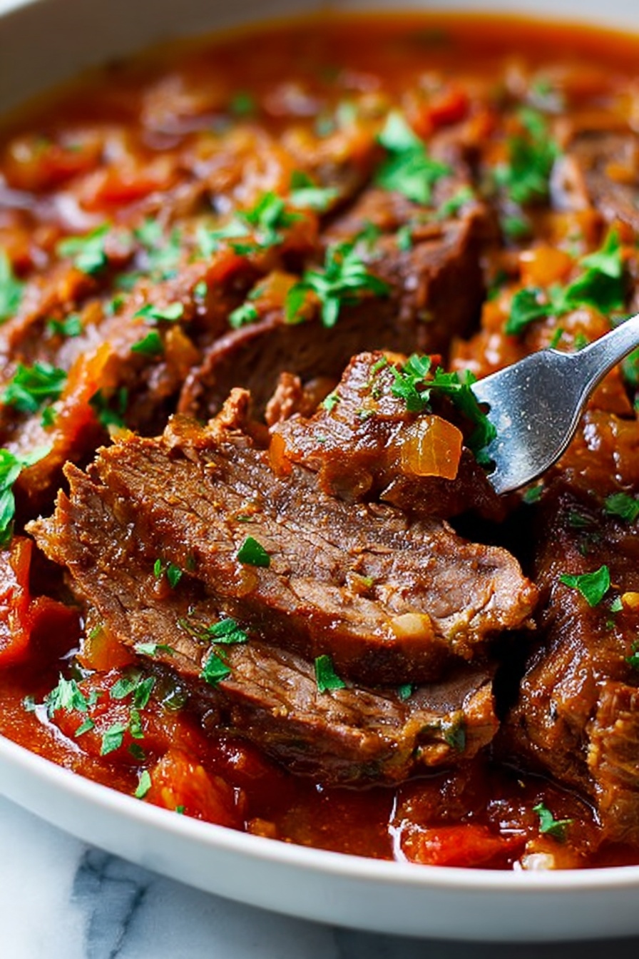 The image shows a close-up of sliced, cooked beef in a sauce with visible pieces of tomato, small chopped onions, and herbs like parsley sprinkled on top. The beef is brown with a slightly flaky texture, sitting in a rich, reddish-brown sauce that looks thick and hearty. A silver fork is picking up one slice of the beef, revealing its inside texture. The dish is in a white bowl on a white marbled surface. The colors are warm and inviting, with the green herbs adding a fresh touch. photo taken with an iphone --ar 2:3 --v 7