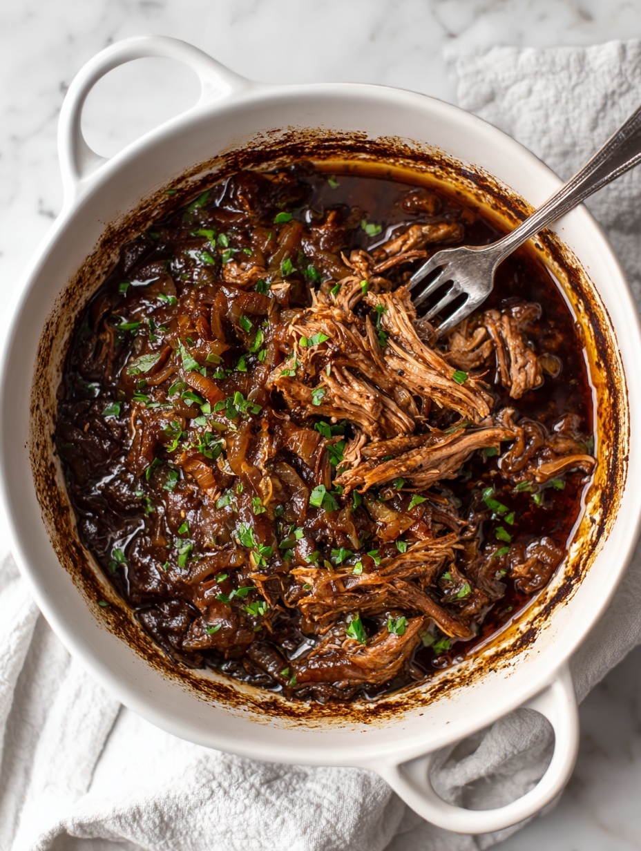 A white round pot holds a rich brown cooked meat dish with a thick dark brown sauce. The meat is tender and shredded in the center, surrounded by soft caramelized onion pieces that cover the top. Small green herb bits are sprinkled on the meat and sauce. A metal two-prong fork is pulling some shredded meat from the center. The inner sides of the pot show dark browned marks from cooking. The pot sits on a white marbled surface with some white and grey cloth underneath. photo taken with an iphone --ar 2:3 --v 7