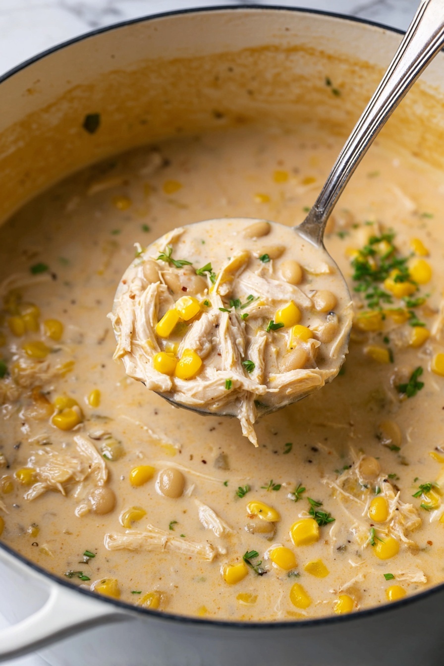 A thick creamy soup is shown in a large white pot with a close-up silver ladle lifting a scoop of the soup. The soup has three main visual layers: a smooth, creamy beige base, irregular pieces of white shredded chicken mixed throughout, scattered bright yellow corn kernels, and light tan beans. Small green herb bits are sprinkled on top, adding a touch of color. The background features a white marbled texture, and the pot’s interior has a slight staining from the soup. Photo taken with an iphone --ar 2:3 --v 7