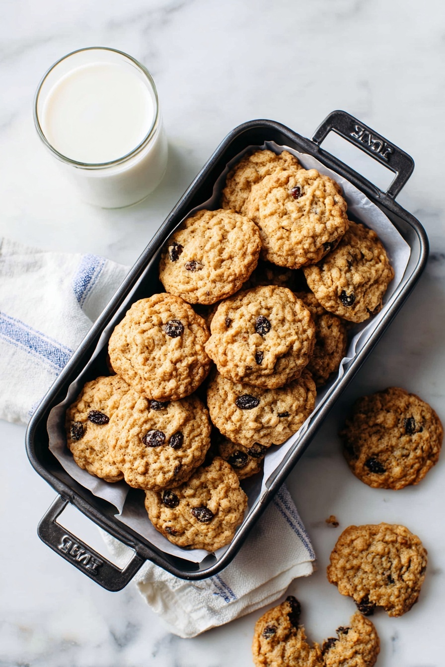 A black rectangular pan filled with two layers of round, light brown oatmeal raisin cookies with visible raisins. The pan is lined with a white cloth with blue stripes. Around the pan on a white marbled surface, there are seven more oatmeal raisin cookies, including one that is broken into pieces showing its soft texture inside. A clear glass of milk is placed near the pan on the left side. Photo taken with an iphone --ar 2:3 --v 7