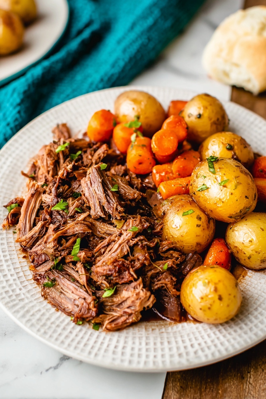 A white textured plate sits on a white marbled surface, with two main layers of food. On the left side, there is a thick layer of shredded brown roasted meat with small green herb pieces sprinkled on top. On the right side, there is a mix of whole golden baby potatoes and bright orange carrot pieces that have a slightly shiny, roasted look, scattered with small green herb bits. The background includes a white biscuit and a teal cloth, adding contrast to the warm colors of the food. Photo taken with an iphone --ar 2:3 --v 7